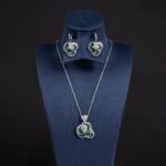 Niche swirl heart crystal jewelry set wholesale featuring an openwork filigree swirl heart pendant necklace studded with cubic zirconia and matching drop earrings from junejewelry.com
