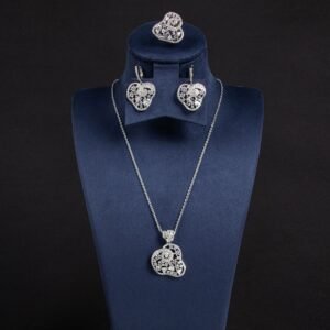 Niche swirl heart crystal jewelry set wholesale featuring an openwork filigree swirl heart pendant necklace, statement ring, and matching drop earrings studded with cubic zirconia from junejewelry.com