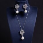 Enhance your online inventory with romantic elegance by adding our Floral pearl drop jewelry set wholesale, available at junejewelry.com. As shown in image LY5561 (4).jpg, this two-piece set artfully combines delicate botanical brilliance with classic luster. Built on an eco-friendly, tarnish-resistant platinum-plated copper base (100% lead, nickel, and cadmium free), each piece features a detailed cluster of tiny pave-set cubic zirconia blossom flowers anchored by a luminous, dangling synthetic pearl drop, paired with matching cluster drop earrings. Presented in brilliant Crystal Clear, this whimsical floral set elevates everyday commuting ensembles, wedding celebrations, formal banquets, and travel wardrobes alike. B2B buyers enjoy exceptional high quality craftsmanship at a cheap factory price designed to maximize retail margins. Order directly on junejewelry.com to benefit from export-grade packaging and free shipping on qualifying bulk wholesale purchases!