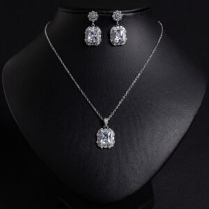 Niche emerald cut crystal jewelry set wholesale featuring a radiant halo CZ rectangular crystal pendant chain necklace and matching drop earrings from junejewelry.com
