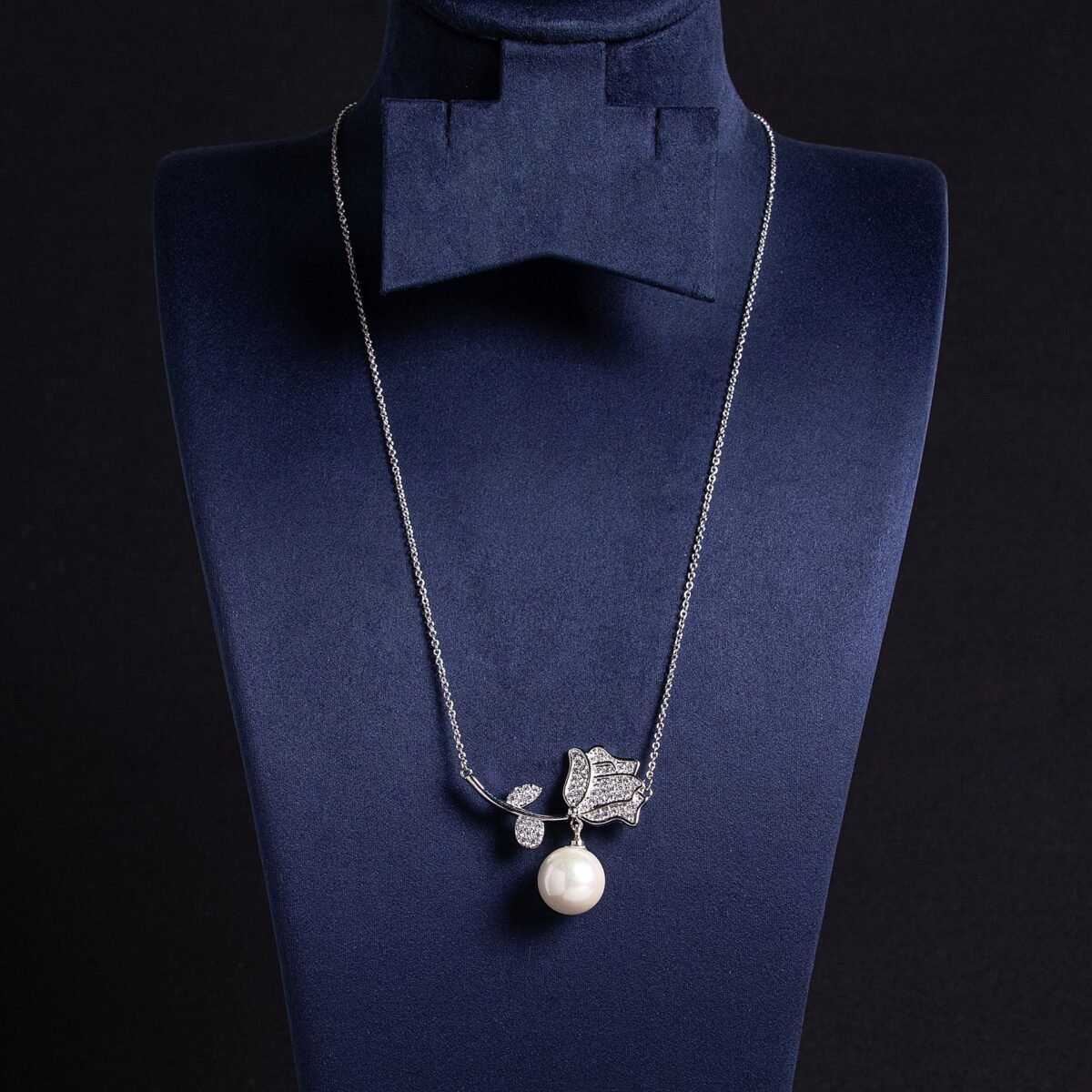 Light luxury rose pearl necklace wholesale featuring a pave CZ rose flower branch with a dangling white pearl pendant chain necklace from junejewelry.com