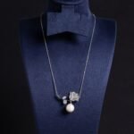 Light luxury rose pearl necklace wholesale featuring a pave CZ rose flower branch with a dangling white pearl pendant chain necklace from junejewelry.com