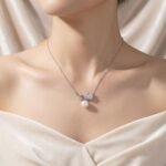Light luxury rose pearl necklace wholesale featuring a pave CZ rose flower branch with a dangling white pearl pendant chain necklace from junejewelry.com