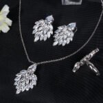 Niche feather crystal cluster jewelry set wholesale featuring marquise CZ leaf cluster pendants topped with pear-cut colored gemstones with matching earrings and ring from junejewelry.com