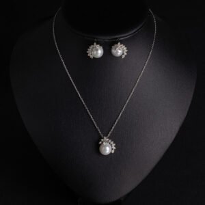 Niche elegant pearl crescent necklace earring set wholesale featuring a micro-pave cubic zirconia curved cap accentuating a lustrous round pearl pendant with matching stud earrings from junejewelry.com