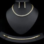 Baguette CZ tennis jewelry set wholesale including necklace, drop earrings, and tennis bracelet featuring emerald-cut cubic zirconia on 18K gold and palladium plated copper.