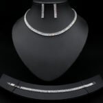 Baguette CZ tennis jewelry set wholesale including necklace, drop earrings, and tennis bracelet featuring emerald-cut cubic zirconia on 18K gold and palladium plated copper.