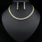 Baguette CZ tennis jewelry set wholesale including necklace, drop earrings, and tennis bracelet featuring emerald-cut cubic zirconia on 18K gold and palladium plated copper.