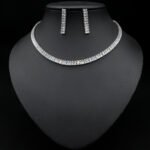 Baguette CZ tennis jewelry set wholesale including necklace, drop earrings, and tennis bracelet featuring emerald-cut cubic zirconia on 18K gold and palladium plated copper.