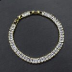 Baguette CZ tennis jewelry set wholesale including necklace, drop earrings, and tennis bracelet featuring emerald-cut cubic zirconia on 18K gold and palladium plated copper.