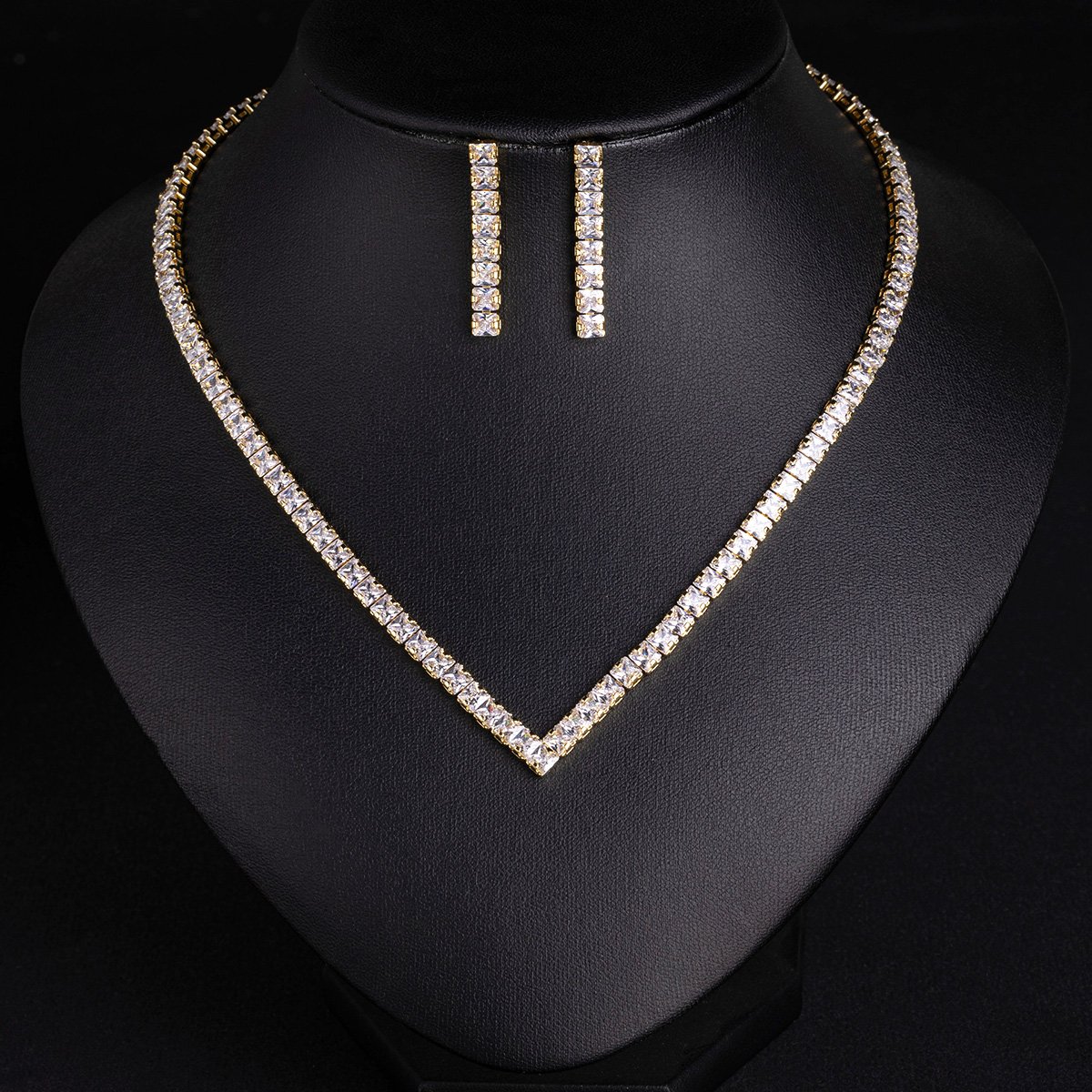 Square CZ V-necklace set wholesale including V-shaped tennis necklace and matching linear dangle drop earrings featuring princess-cut cubic zirconia on 18K gold and palladium plated copper base.