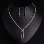 Niche lariat tennis necklace jewelry set wholesale featuring a Y-shaped drop tennis necklace and linear dangle drop earrings with sparkling cubic zirconia accents from junejewelry.com