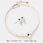 Niche small pearl necklace jewelry set wholesale featuring delicate round faux pearls, an emerald-green cubic zirconia center accent, and matching pearl stud earrings from junejewelry.com