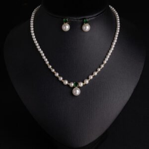 Niche small pearl necklace jewelry set wholesale featuring delicate round faux pearls, an emerald-green cubic zirconia center accent, and matching pearl stud earrings from junejewelry.com