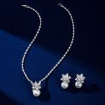 Niche snowflake pearl pendant jewelry set wholesale featuring a cubic zirconia tennis necklace with a snowflake crystal star burst and smooth pearl pendant, paired with matching pearl drop earrings from junejewelry.com
