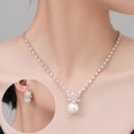 Niche snowflake pearl pendant jewelry set wholesale featuring a cubic zirconia tennis necklace with a snowflake crystal star burst and smooth pearl pendant, paired with matching pearl drop earrings from junejewelry.com