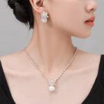 Niche snowflake pearl pendant jewelry set wholesale featuring a cubic zirconia tennis necklace with a snowflake crystal star burst and smooth pearl pendant, paired with matching pearl drop earrings from junejewelry.com