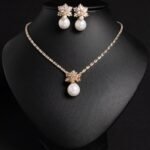 Niche snowflake pearl pendant jewelry set wholesale featuring a cubic zirconia tennis necklace with a snowflake crystal star burst and smooth pearl pendant, paired with matching pearl drop earrings from junejewelry.com