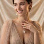 Niche teardrop shell pearl zircon jewelry set wholesale featuring a pear-shaped mother-of-pearl drop topped with a round green agate gem and crystal linear chain, paired with matching drop earrings from junejewelry.com
