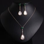 Niche teardrop shell pearl zircon jewelry set wholesale featuring a pear-shaped mother-of-pearl drop topped with a round green agate gem and crystal linear chain, paired with matching drop earrings from junejewelry.com