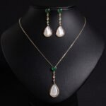 Niche teardrop shell pearl zircon jewelry set wholesale featuring a pear-shaped mother-of-pearl drop topped with a round green agate gem and crystal linear chain, paired with matching drop earrings from junejewelry.com