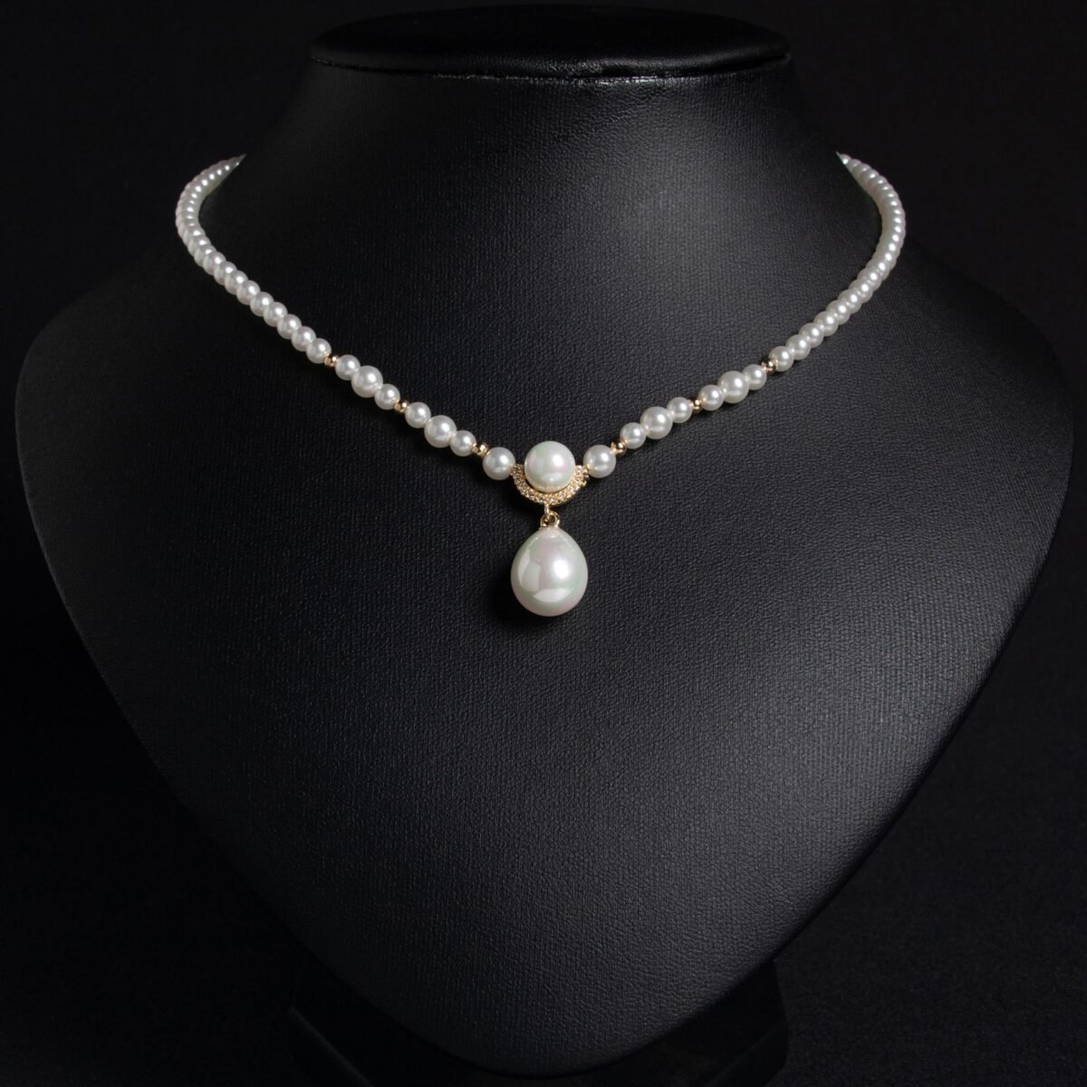 Light luxury tear drop pearl strand necklace wholesale featuring a delicate white pearl bead chain with a pave CZ arched crown connector and large teardrop pearl pendant from junejewelry.com