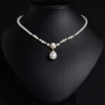 Light luxury tear drop pearl strand necklace wholesale featuring a delicate white pearl bead chain with a pave CZ arched crown connector and large teardrop pearl pendant from junejewelry.com