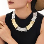 Model wearing 18K gold plated textured curved plate statement collar choker necklace