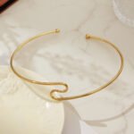 Model wearing 18K gold plated minimalist open wave torque choker necklace