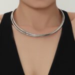 Model wearing gold plated minimalist rigid wire torque collar choker necklace in stainless steel