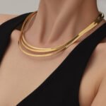 Model wearing gold plated minimalist rigid wire torque collar choker necklace in stainless steel