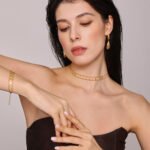 Stainless steel gold double layer chain necklace and matching bracelet set featuring geometric rhombus dangling charms.