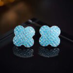Wholesale turquoise pave earrings collection featuring micro-pave turquoise studs, huggie hoops, pearl drops, swan, and flower designs.