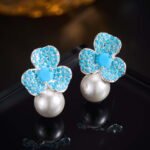 Wholesale turquoise pave earrings collection featuring micro-pave turquoise studs, huggie hoops, pearl drops, swan, and flower designs.
