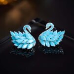 Wholesale turquoise pave earrings collection featuring micro-pave turquoise studs, huggie hoops, pearl drops, swan, and flower designs.