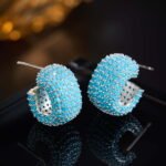Wholesale turquoise pave earrings collection featuring micro-pave turquoise studs, huggie hoops, pearl drops, swan, and flower designs.