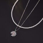 Niche layered daisy pearl necklace wholesale featuring a dual-strand design with a full pearl choker strand and a fine silver chain suspending a micro-pave cubic zirconia daisy pendant from junejewelry.com