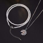 Niche layered daisy pearl necklace wholesale featuring a dual-strand design with a full pearl choker strand and a fine silver chain suspending a micro-pave cubic zirconia daisy pendant from junejewelry.com