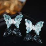 Niche ice translucent butterfly zircon jewelry set wholesale featuring carved crystal butterfly wings with marquise zircon bodies on a fine chain pendant necklace and matching stud earrings from junejewelry.com