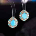 Niche vintage blue gemstone pearl jewelry set wholesale featuring an oval turquoise-blue cabochon surrounded by a halo of micro-pave zircons and turquoise accents on a pearl strand necklace with matching stud earrings from junejewelry.com