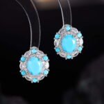 Niche vintage blue gemstone pearl jewelry set wholesale featuring an oval turquoise-blue cabochon surrounded by a halo of micro-pave zircons and turquoise accents on a pearl strand necklace with matching stud earrings from junejewelry.com