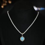Niche vintage blue gemstone pearl jewelry set wholesale featuring an oval turquoise-blue cabochon surrounded by a halo of micro-pave zircons and turquoise accents on a pearl strand necklace with matching stud earrings from junejewelry.com