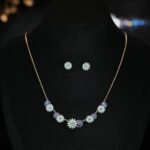 Niche daisy flower enamel necklace earring set wholesale featuring a crescent arrangement of multi-colored enamel daisy blossoms with pave zircon centers and matching daisy stud earrings from junejewelry.com