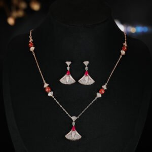 Niche fan shape pendant necklace earring set wholesale featuring a fan-shaped motif inlaid with mother-of-pearl, pave zircons, and a vibrant red teardrop gemstone from junejewelry.com