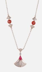 Niche fan shape pendant necklace earring set wholesale featuring a fan-shaped motif inlaid with mother-of-pearl, pave zircons, and a vibrant red teardrop gemstone from junejewelry.com