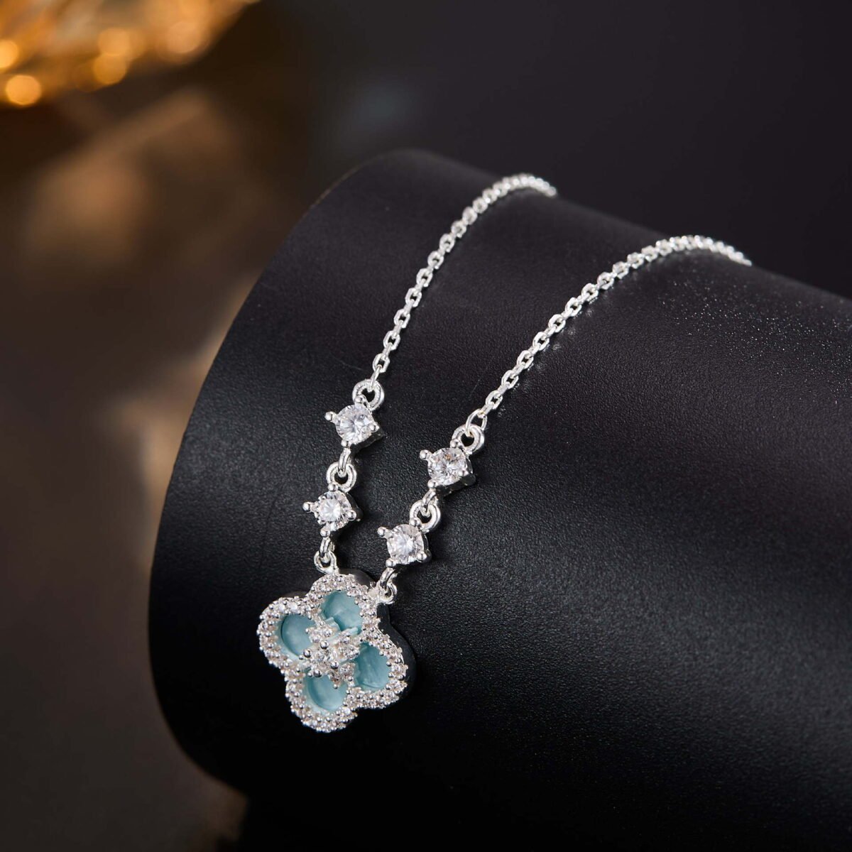 Niche four leaf clover pendant necklace wholesale featuring a four-petal clover motif framed with micro-pave cubic zirconia and round crystal stations along the chain from junejewelry.com