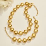 Chunky stainless steel necklace and bracelet jewelry set featuring smooth high-polish round flat disc beads in gold and silver finishes.
