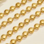 Chunky stainless steel necklace and bracelet jewelry set featuring smooth high-polish round flat disc beads in gold and silver finishes.