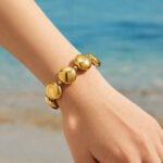 Chunky stainless steel necklace and bracelet jewelry set featuring smooth high-polish round flat disc beads in gold and silver finishes.