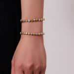 Two-tone gold and silver stainless steel jewelry set featuring alternating smooth silver beads, gold star motifs, textured gold station beads, and a sleek snake chain.